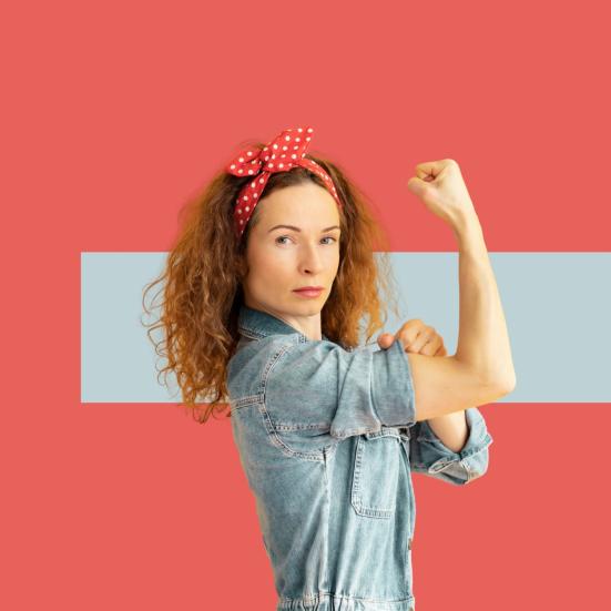 Kvinde viser stærk arm og knyttet næve